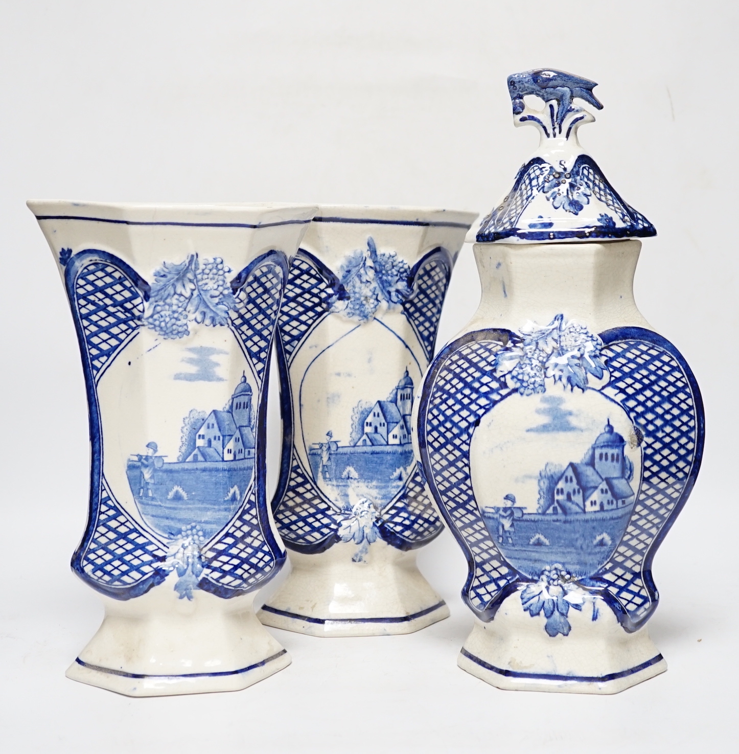 A trio of cream and blue glazed pottery vases, one with cover, tallest 34cm high